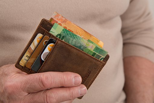 Man holding a wallet full of money